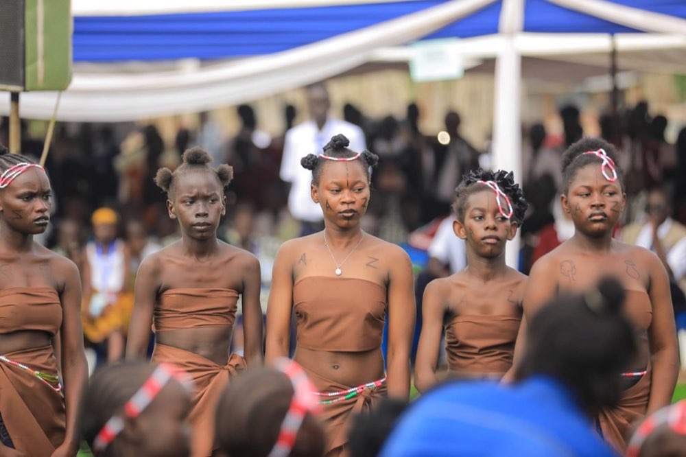 A line of young dancers in traditional dress performing before a crowd at Peace Cultural Day