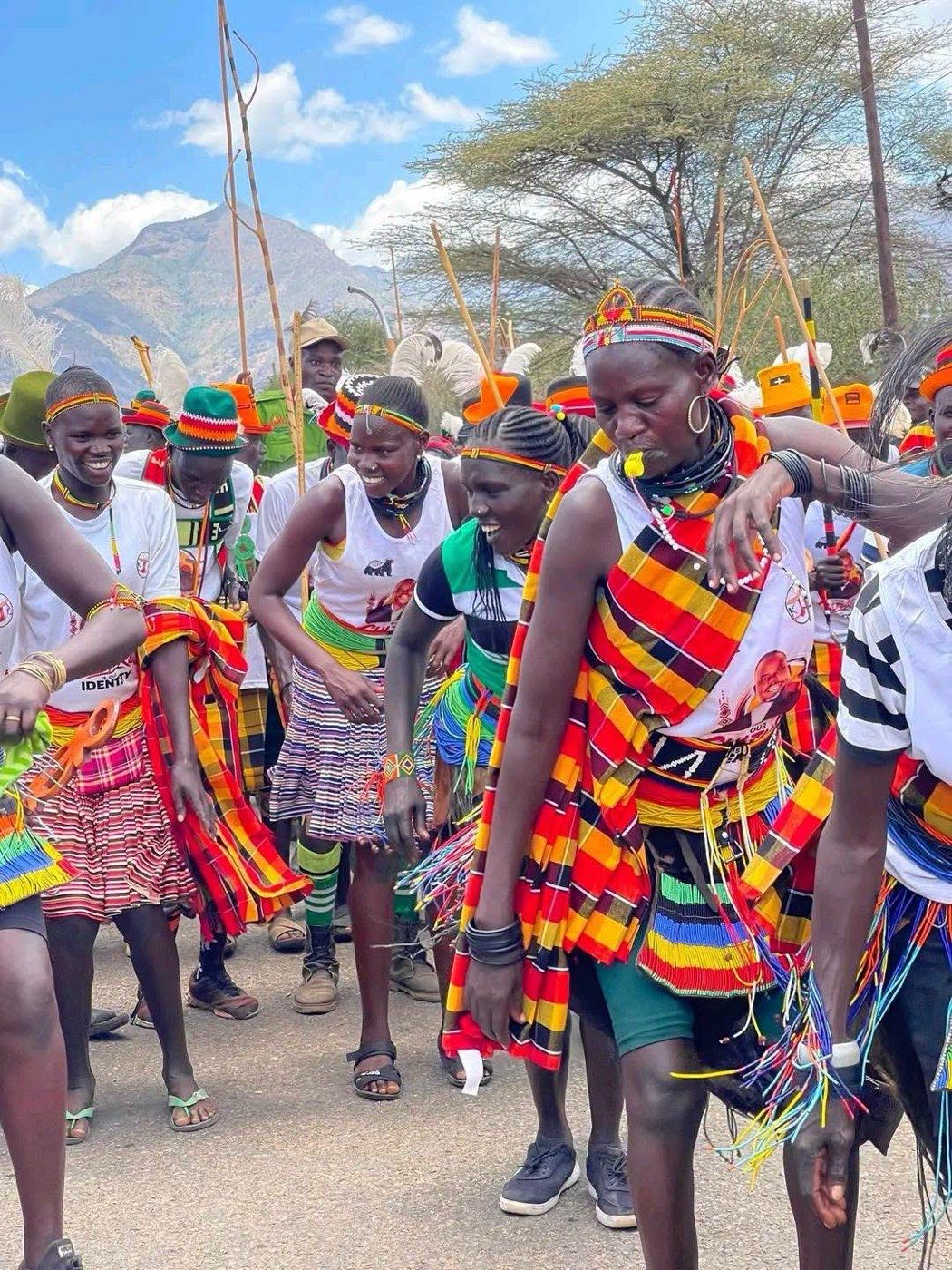 Young people in traditional beaded dress dance together at a cultural celebration