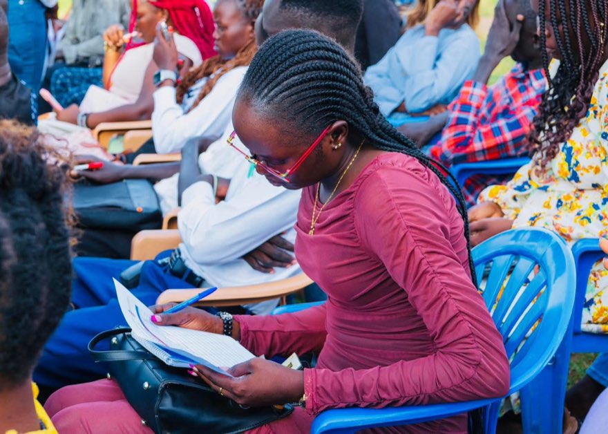 A young woman reads through her notes during a workshop in Kiryandongo Refugee Settlement