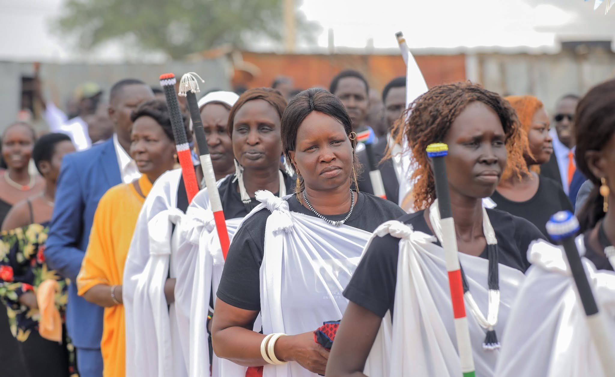 Women in white robes walk in procession during Peace Cultural Day in Kiryandongo Refugee Settlement